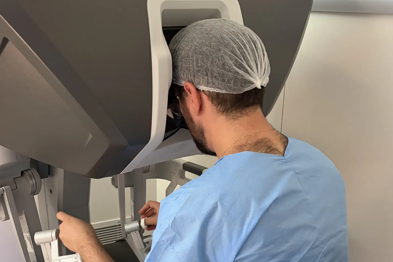 Dr. Alexandre Ziomkowski paramentado ao console do sistema robótico da Vinci
